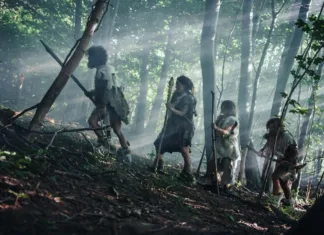 Znanstveniki predlagajo novo človeško vrsto Tribe of Hunter-Gatherers Wearing Animal Skin Holding Stone Tipped Tools, Explore Prehistoric Forest in a Hunt for Animal Prey. Neanderthal Family Hunting in the Jungle or Migrating for Better Land