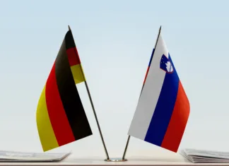 V Sloveniji največ Nemcev Two table flags of Germany and Slovenia