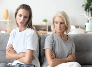 Zakaj vse več mladih prekinja stike s starši? Upset older mother in law and adult daughter sit back to back not talking after fight disagreement, two stubborn old young women ignoring avoiding each other sad by argument, family conflict concept