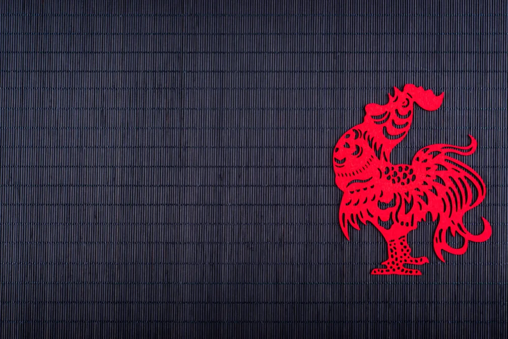 Silhouette of rooster on black bamboo mat, copy space, Chinese New Year 2017 symbol