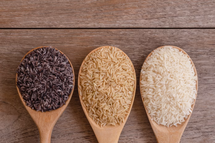 Variety type and color of rice ; paddy rice, riceberry ,brown coarse rice and white thai jasmine rice in wooden spoon  isolated on old rustic wood table background. Healthy food concept. Flat lay.