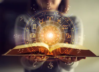 3 horoskopska znamenja, ki bodo v letu 2025 prejela srečo, rast in uspeh Woman holding a astrology book. Astrological wheel projection, choose a zodiac sign. Astrology esoteric concept.