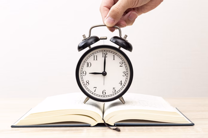 A book and a clock on the desk.