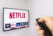 Velika Netflix prevara, uporabnikom izdano rdeče opozorilo! Preverite, ali imate v svojem poštnem predalu zaskrbljujoče sporočilo Calgary, Alberta. Canada Dec 9 2019: A Person holds an Apple TV remote using the new Netflix app with a hand. Netflix dominates Golden Globe Nominations. Illustrative
