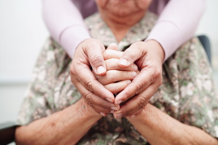 caregiver-holding-hands-asian-elderly-woman-patient-help-and-care-in-hospital-stockpack-istock Caregiver holding hands Asian elderly woman patient, help and care in hospital.