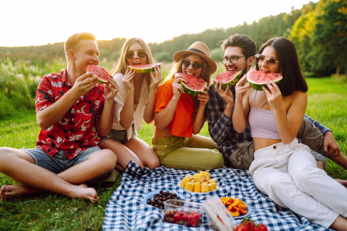 group-of-friends-having-fun-eating-watermelon-on-the-picnic-outdoors-foods-travel-nature-and-vacation-concept-stockpack-istock Group of friends having fun eating watermelon on the picnic outdoors. Foods, travel, nature and vacation concept.