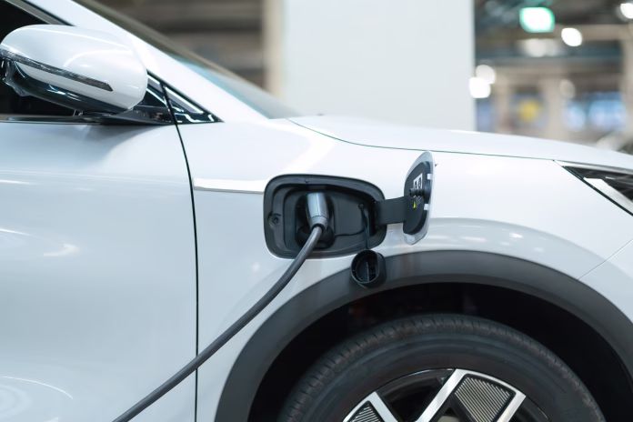 Power cable pump plug in charging power to electric vehicle EV car with modern technology UI control information display, car fueling station connected power cable alternative sustainable eco energy