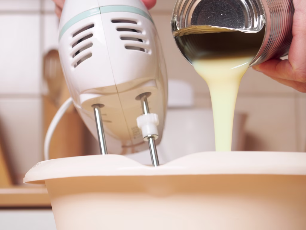 Adding sweetened condensed milk. Making butter cream filling. Making torte with buttercream filling and grated chocolate topping. Series.