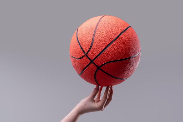 Baseball held in balance by a female hand, isolated by color. It could symbolize basketball as much as the ball itself, or sports, mental equilibrium as much as physical balance.