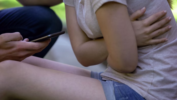 Closeup of girl suffering abdominal pain, worried man calling ambulance, help