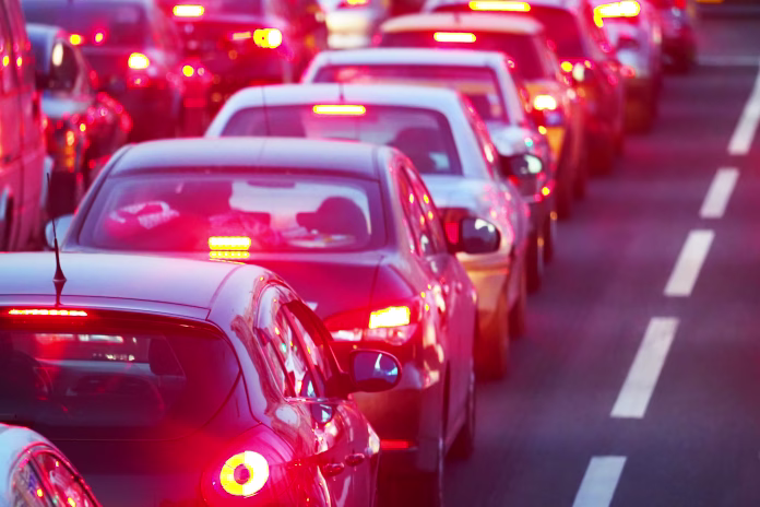 Evening, city traffic jams, street road. Standing in a row cars, rear view, red stop lights. Dividing strip