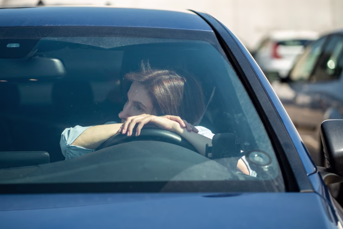 exhausted-female-sit-on-driver-seat-of-car-not-driving-look-through-windshield-thinking-frustrated-woman-suffering-money-crisis-troubles-at-work-or-relationship-breakup-pondering-inside-auto-vehicle-stockpack-istock Exhausted female sit on driver seat of car not driving look through windshield thinking. Frustrated woman suffering money crisis, troubles at work or relationship breakup pondering inside auto vehicle