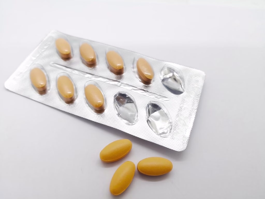 Medication concept. Brown tablet drug used for venous circulation disorder and for acute hemorrhoidal attack, that were removed from blister. Isolated on white background and copy space.