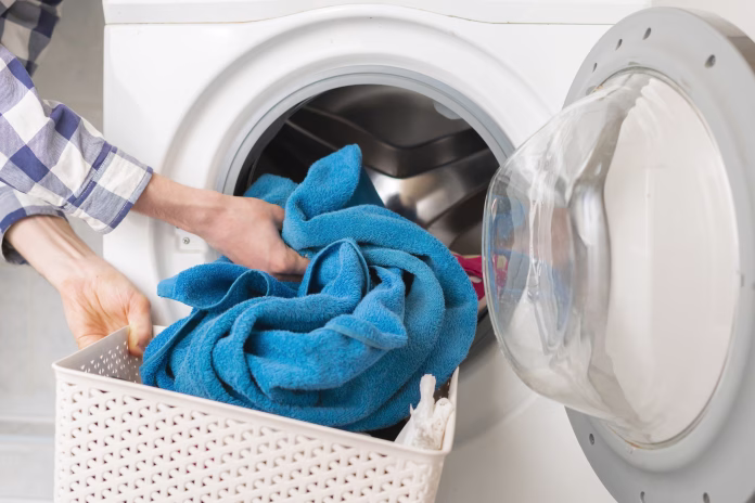 persons-hand-put-dirty-clothes-in-the-washing-machine-stockpack-istock persons hand put dirty clothes in the washing machine