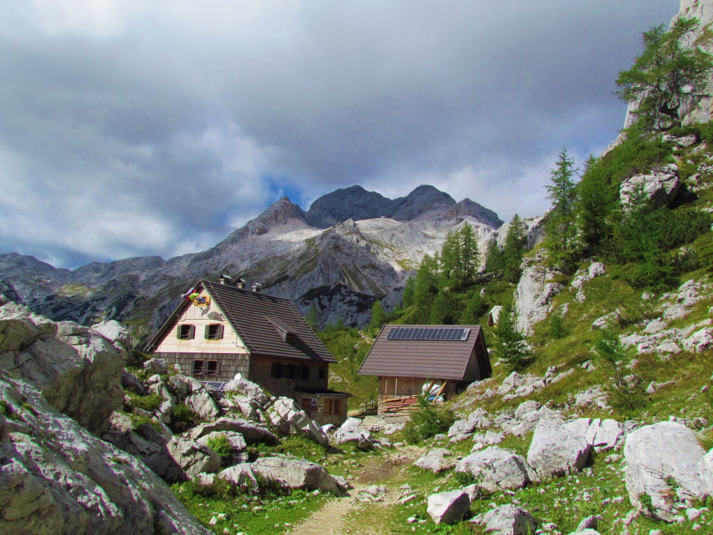 Scenic view of mountain hut Vodnikov dom na Velem Polju and mountain Triglav in the background in Triglav national park and Julian alps in Gorenjska region of Slovenia
