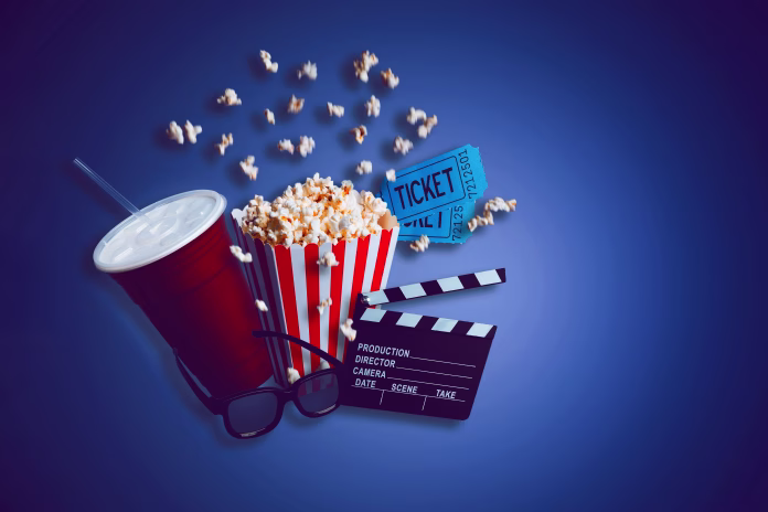 cinema-theater-concept-composite-of-a-box-of-popcorn-a-large-drink-a-clapperboard-some-3d-glasses-and-a-couple-of-movie-tickets-on-a-dark-blue-background-stockpack-istock Cinema theater concept. Composite of a box of popcorn, a large drink, a clapperboard, some 3D glasses and a couple of movie tickets on a dark blue background.