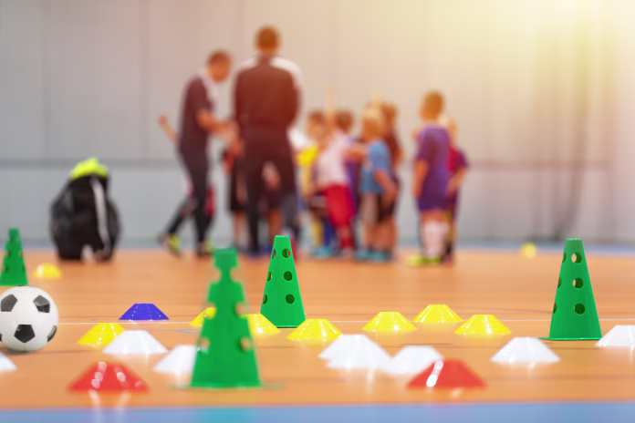 Futsal Soccer Training Court. Kids in a Group With Coaches in Blurred Background. Kids on Physical Education Class at School