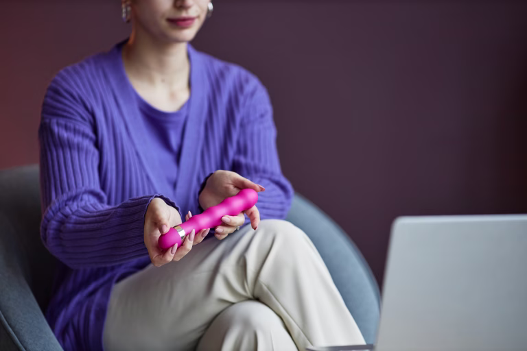 Hands of sexologist offering client to try using vibrator to add extra stimulation and increase feelings of sexual pleasure
