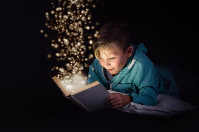 blond boy reading a magicical story book with light leaping off the page