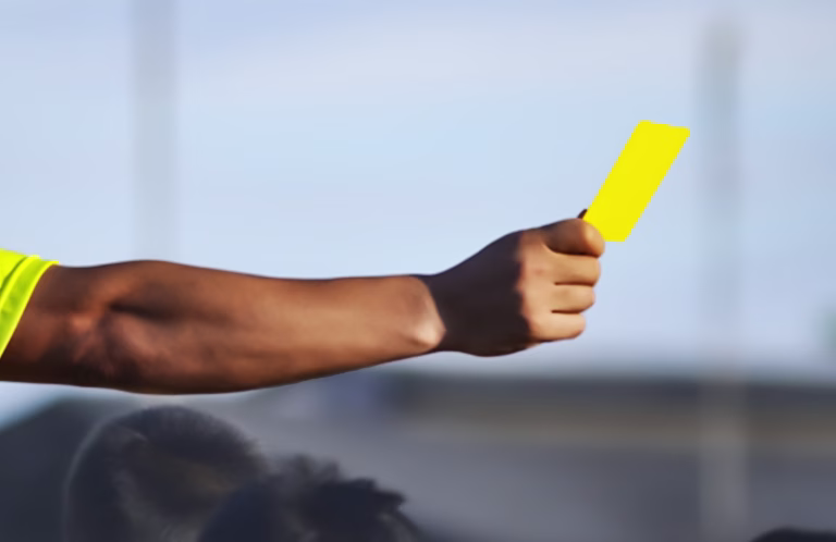 Close up image of a hand showing a yellow card