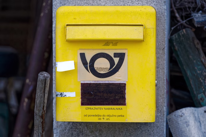 close-up-of-yellow-letter-box-outdoors-at-rural-slovenian-village-of-sutna-on-a-cloudy-summer-evening-photo-taken-august-10th-2023-sutna-slovenia-stockpack-istock Close-up of yellow letter box outdoors at rural Slovenian village of Sutna on a cloudy summer evening. Photo taken August 10th, 2023, Šutna, Slovenia.