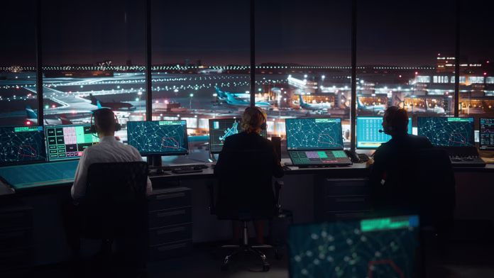 diverse-air-traffic-control-team-working-in-a-modern-airport-tower-at-night-office-room-is-full-of-desktop-computer-displays-with-navigation-screens-airplane-flight-radar-data-for-controllers-stockpack-istock Diverse Air Traffic Control Team Working in a Modern Airport Tower at Night. Office Room is Full of Desktop Computer Displays with Navigation Screens, Airplane Flight Radar Data for Controllers.