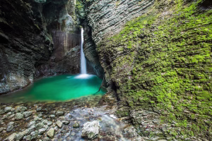 Emerald colored water in the pool of the Kozjak waterfall in the Triglav National Park of Slovenia