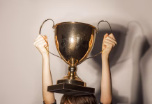 Državna priznanja v mladinskem sektorju, objavljen je javni poziv Golden color trophy cup in the hands of boy, close-up