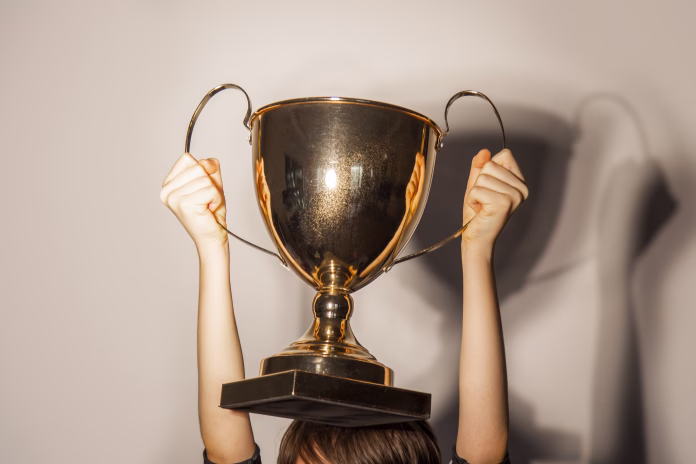 golden-color-trophy-cup-in-the-hands-of-boy-close-up-stockpack-istock Golden color trophy cup in the hands of boy, close-up