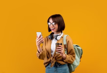 Ponudniki subvencionirane študentske prehrane se lahko prijavijo na razpis Happy female student with backpack, headphones, smartphone and takeaway coffee standing over yellow studio background. Young lady ready for classes, chatting on cellphone