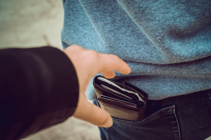 one hand reaches for a purse in the back pocket