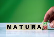 Novosti pri maturi: kako se spreminja srednje šolstvo? The hand turns the wooden cube and changes the polish word MATURA (english = secondary school certificate) with green positive tick check box and red reject X check box.