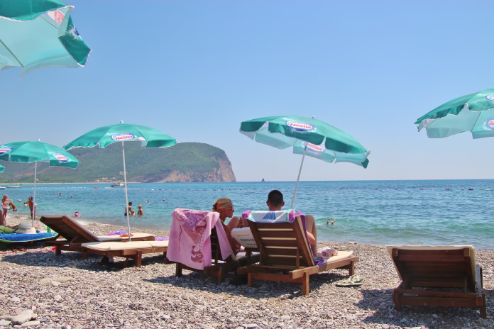 Valdanos, Montenegro – July 22, 2017: People and sunshades on the beach of Valdanos. Near Ulcinj, South-East Europe.