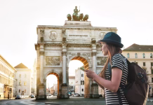 Takšni so dejanski stroški študija v Münchnu, najdražjem mestu v Nemčiji A tourist girl with a backpack looks sights in Munich in Germany. Passes by the triumphal arch.