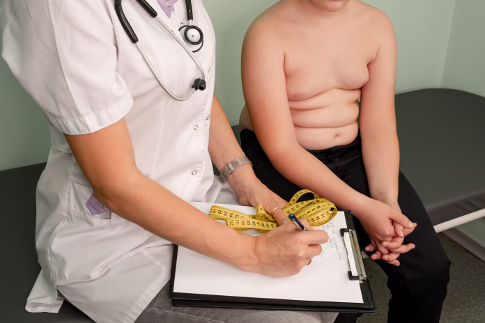 childhood-obesity-problem-and-weight-loss-fat-boy-at-a-nutritionist-appointment-overweight-boy-consulting-with-doctor-in-office-doctor-examining-fat-boy-in-clinic-doctor-measuring-overweight-boy-stockpack-istock Childhood obesity problem and weight loss. Fat boy at a nutritionist appointment. Overweight boy consulting with doctor in office. Doctor examining fat boy in clinic. Doctor measuring overweight boy.