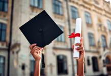 Kaj je terciarna izobrazba? Cropped image of graduate holding academic hat and diploma with red ribbon. Happy graduation, bright future, success and confidence.