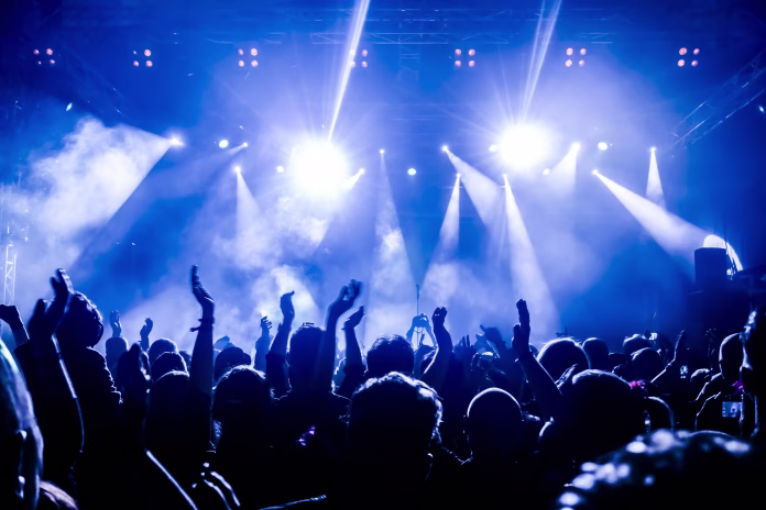 crowd-with-arms-raised-during-concert-stockpack-istock Crowd With Arms Raised During Concert