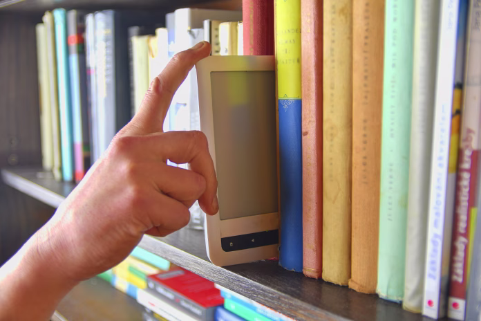 electronic-book-picked-from-a-library-shelf-the-electronic-book-on-a-bookshelf-among-the-many-books-in-the-library-books-and-library-concept-stockpack-istock Electronic book picked from a library shelf. The electronic book on a bookshelf among the many books in the library. Books and library concept.