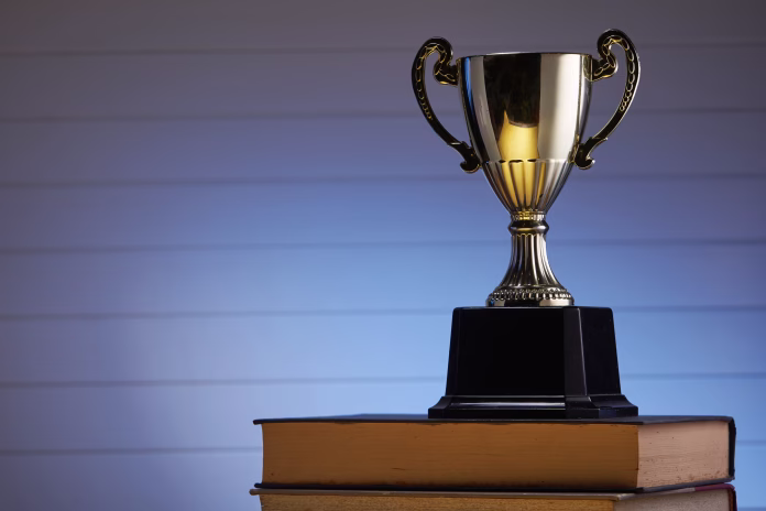 Golden trophy and book, learning and achievement concept