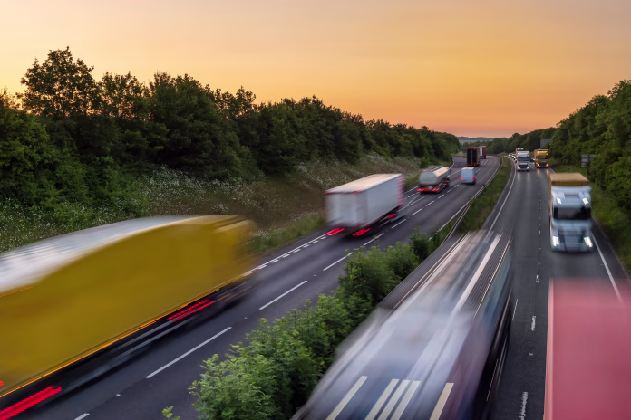 heavy traffic moving at speed on UK motorway in England at sunset