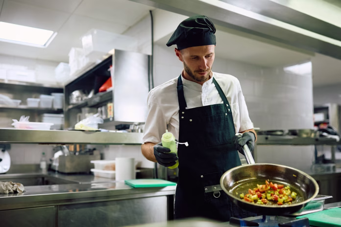 Professional chef working in the kitchen in a restaurant. Copy space.