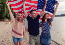 Študij v ZDA s Kerže skladi, kaj omogočajo letos? Shot of young friends carrying american flag on the beach
