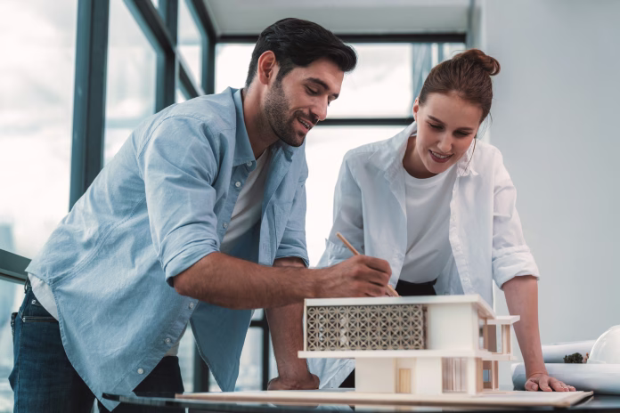 Smart caucasian architect engineer team working together to measure house model. Group of professional interior designer brainstorming and sharing ideas about design building construction. Tracery.