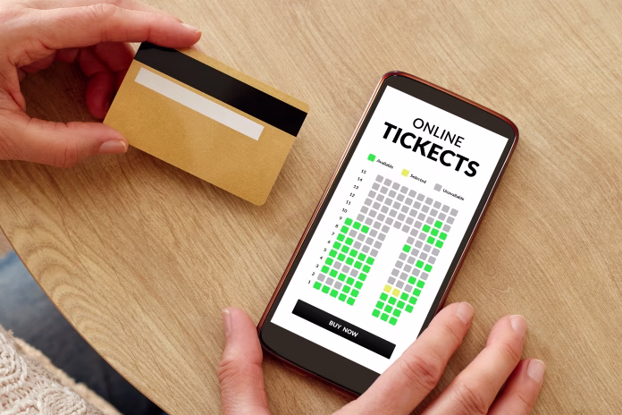 Close-up photo of female hands with credit card making mobile payment for event cinema tickets. Online show theater tickets booking.