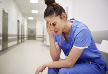 Epidemija izgorelosti med zdravstvenimi delavci v Evropi Female nurse suffering from headache