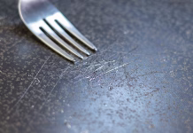 Kuhanje ne bo več tako zdravju nevarno – znanstveniki razvili bolj zdrav premaz proti prijemanju Fork in scratched non-stick coated pan. Dangerous chemicals in cookware.