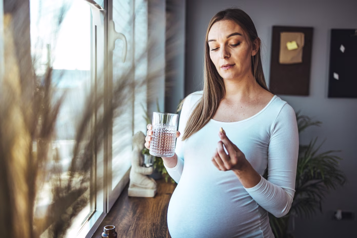 Happy woman holds pill glass of water, takes daily medicine vitamin D, omega 3 supplements, skin hair nail strengthen and beauty, medication for health care concept