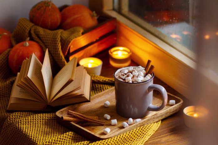 mug-of-cocoa-or-hot-chocolate-with-marshmallows-next-to-the-window-with-candles-pumpkins-book-and-warm-blanket-cozy-home-atmosphere-in-rainy-autumn-day-nygge-lifestyle-concept-stockpack-istock Mug of cocoa or hot chocolate with marshmallows next to the window with candles, pumpkins, book and warm blanket. Cozy home atmosphere in rainy autumn day. Нygge lifestyle concept