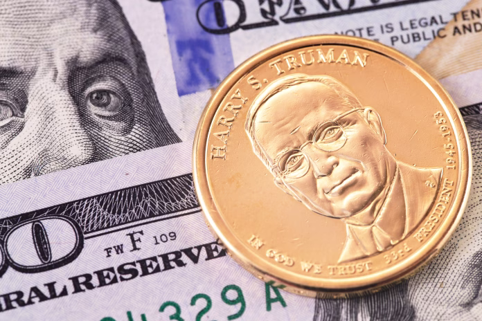 one-dollar-golden-coin-with-harry-s-truman-portrait-and-hundred-dollars-banknotes-macro-stockpack-istock one dollar golden coin with Harry S. Truman portrait, and hundred dollars banknotes, macro