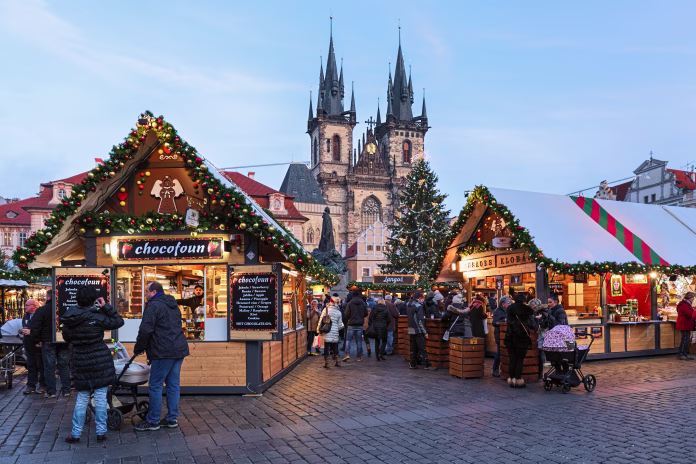 prague-czech-republic-december-11-2019-christmas-market-at-old-town-square-with-the-citys-main-christmas-tree-close-to-jan-hus-monument-in-the-evening-the-gothic-church-of-our-lady-before-tyn-is-locat-stockpack-istock Prague, Czech Republic - December 11, 2019: Christmas market at Old Town Square with the city's main Christmas tree close to Jan Hus Monument in the evening. The Gothic church of Our Lady before Tyn is located in the background. Unknown people walk around the market stalls.